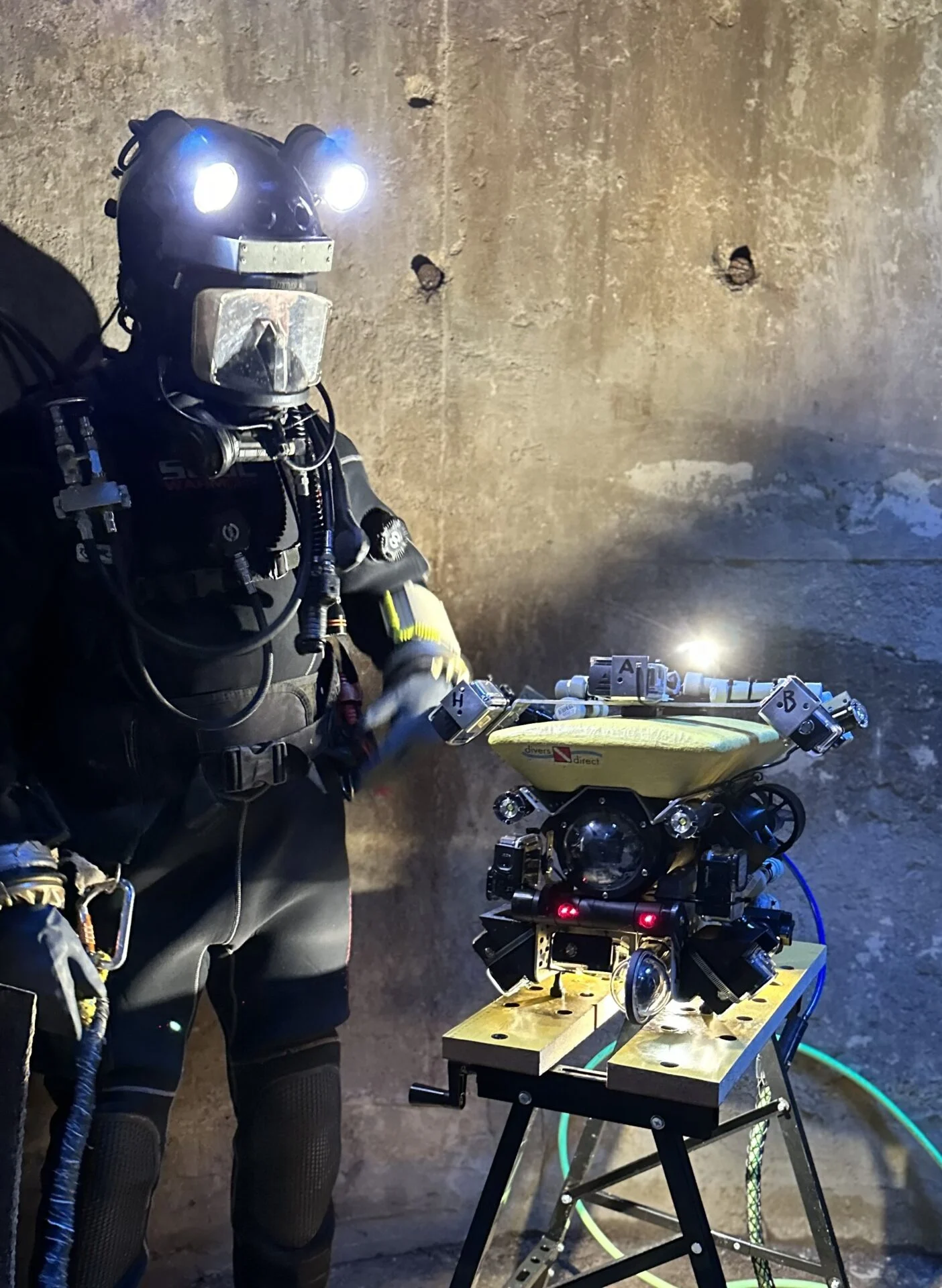 Potápěč v přilbě vedle žlutého průzkumného robota Robíka